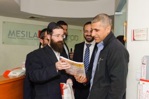 Rabbi Mernstein showing Mesila material to Amir Levy, director of Budgets Department, Ministry of Finance